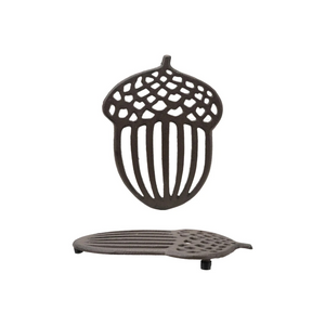 Cast iron acorn-shaped trivet on a white background