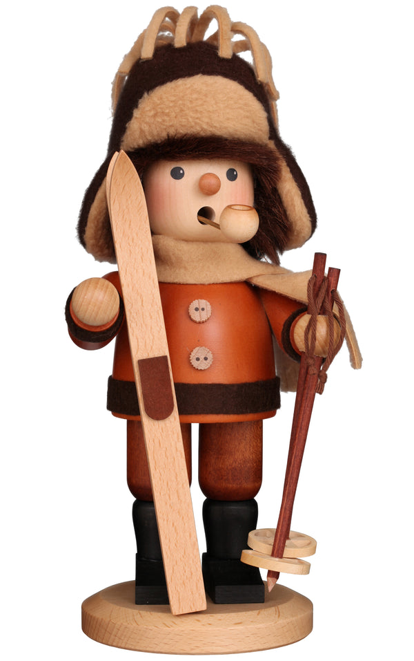 Wooden figurine of a skier with a hat and skis on a white background