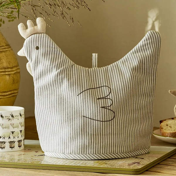 Striped chicken-shaped tea cosy on a wooden surface with a neutral background