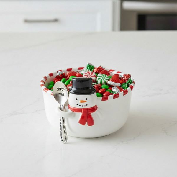 A white ceramic Christmas-themed snack bowl with a snowman figure holding a spoon inside. The bowl features red and white striped trim and the text 'Snow better snacks' printed inside.