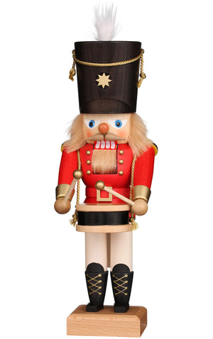 Christian Ulbricht wooden nutcracker in a red coat and tall dark hat with a white plume, holding drumsticks over a wooden drum.