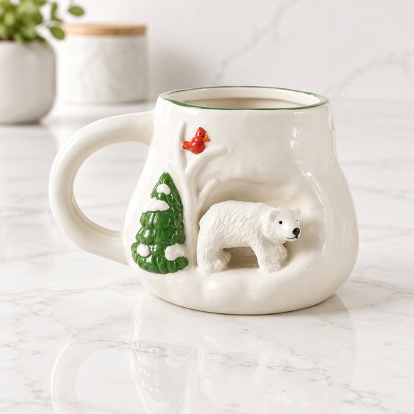 White stoneware mug with a raised 3D polar bear beside an evergreen tree and a red cardinal.