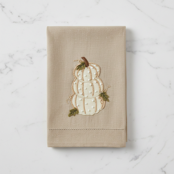 Beige towel with embroidered gourd design on a white background