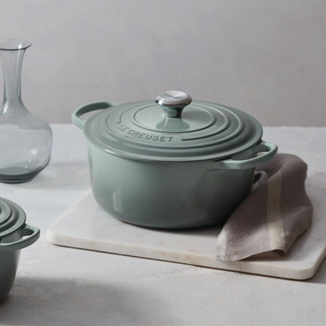 Sea Salt Le Creuset Round Dutch Oven on a white surface with a neutral background