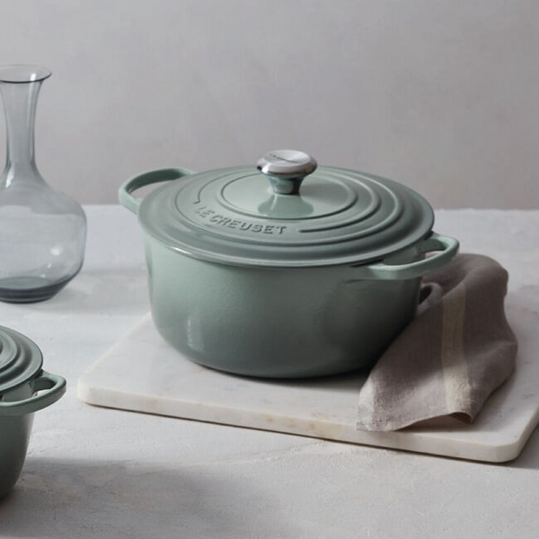 Sea Salt Le Creuset Round Dutch Oven on a white surface with a neutral background