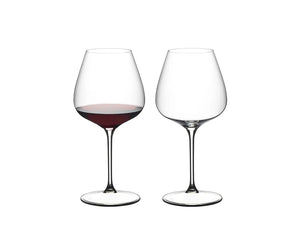 Two clear stemmed wine glasses on a white background, with the left glass partially filled with red wine and the right glass empty.