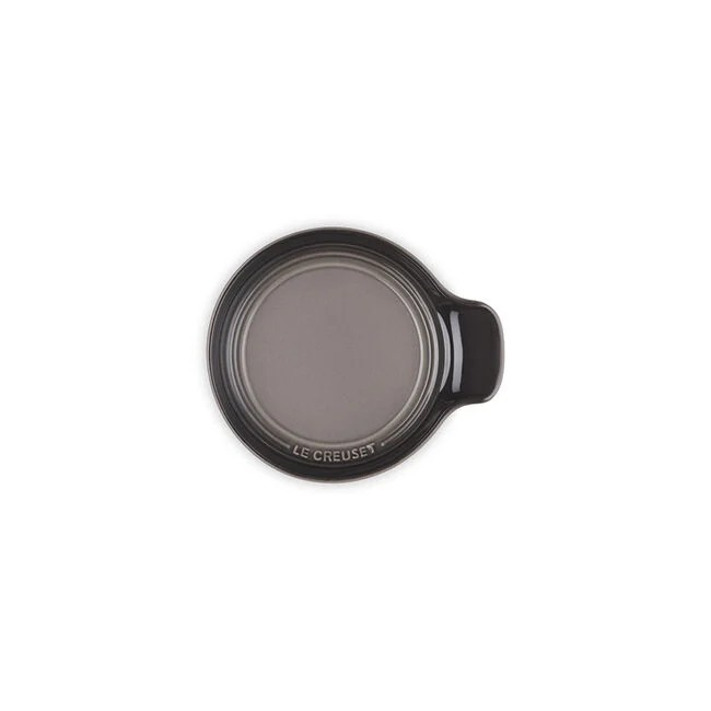 Red Le Creuset pot with a wooden spoon on a light gray surface