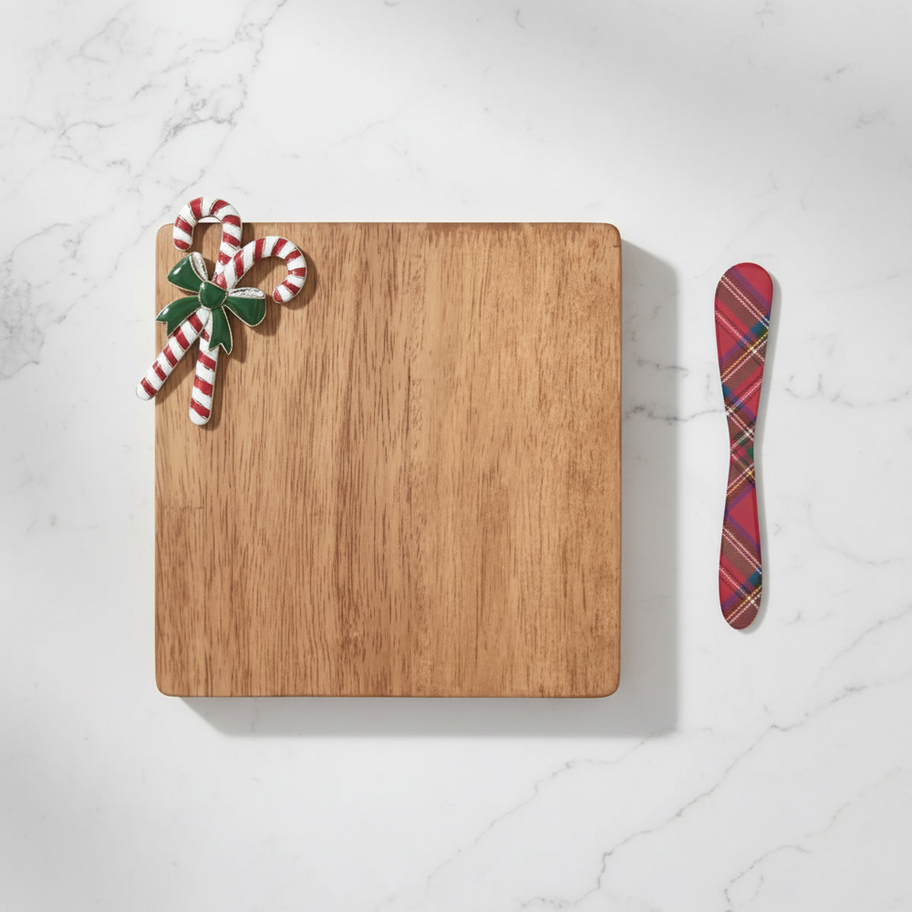 Wooden cutting board with candy cane decorations and a plaid spreader on a white background