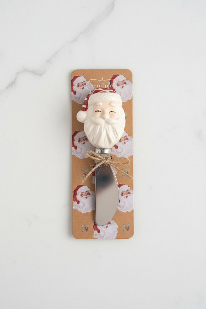 Four Christmas-themed decorative spreader handles mounted on tan patterned cards against a white background. The designs include a snowman, a wreath with a red bow, Santa Claus, and a Christmas tree with a yellow star.