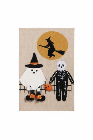 A rectangular Halloween-themed textile or wall hanging on a white background, featuring a witch riding a broomstick in front of an orange full moon, with a ghost and a skeleton figure below on a black fence. A gray 'Click to zoom' button appears below the product.