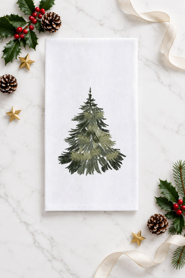 White flour sack kitchen towel with an embroidered evergreen tree in varying shades of green.
