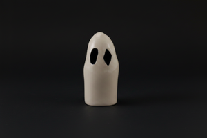 White ghost-shaped object with black eyes on a white background