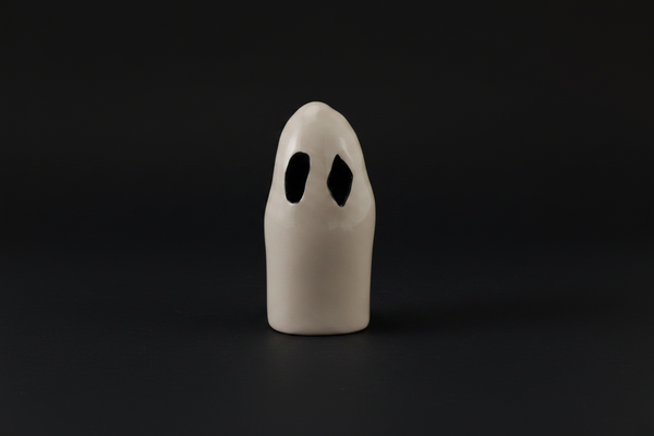 White ghost-shaped object with black eyes on a white background