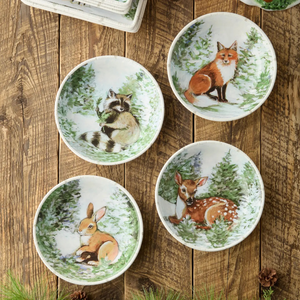 Wide porcelain soup bowl with a painted winter scene of snowy evergreens and woodland wildlife.