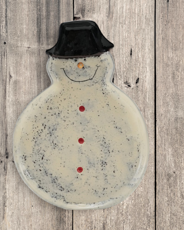 Aspen Kitchens Home+Gift hand-painted ceramic snowman dish with a black hat and speckled reactive glaze finish.