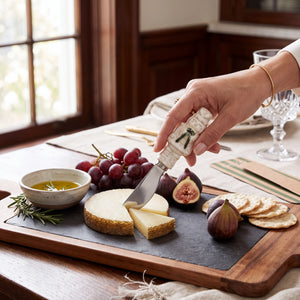 Aspen Kitchens Home+Gift nutcracker ceramic spreader cutting cheese on a slate board with figs and crackers