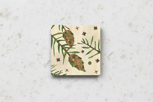 Aspen Kitchens Home+Gift square ceramic coaster featuring a rustic hand-painted pinecone and pine needle design.