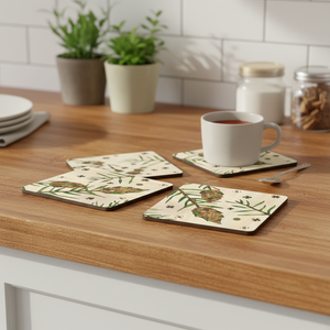 Aspen Kitchens Home+Gift ceramic coasters featuring a rustic pinecone and branch pattern on a wooden kitchen counter.
