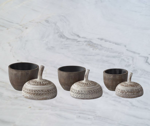 Aspen Kitchens Home+Gift resin acorn containers with carved whitewashed lids in three sizes on a marble surface.