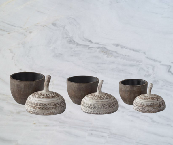 Aspen Kitchens Home+Gift resin acorn containers with carved whitewashed lids in three sizes on a marble surface.