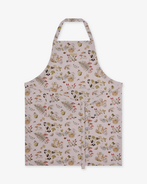A taupe apron with an all-over autumn-themed print of pumpkins, ferns, acorns, and leaves, shown flat against a solid white background.