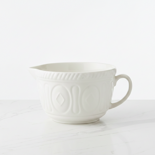 White ceramic batter bowl with embossed design on a white background