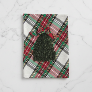 A rectangular kitchen towel with a red, green, and white plaid pattern, featuring a dark green tiered Christmas tree applique tied with a matching plaid bow at the top.