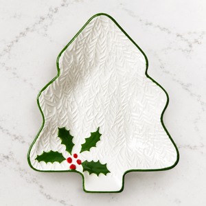 Christmas tree-shaped plate with holly design on a white background