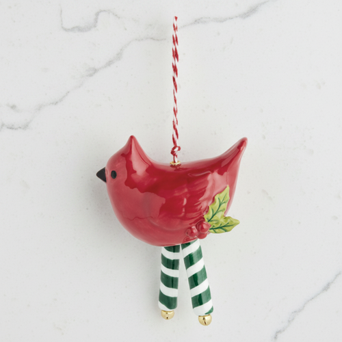 A ceramic Christmas ornament shaped like a red bird with green-and-white striped legs and a small holly leaf detail, hanging from a red-and-white striped string on a plain white background.