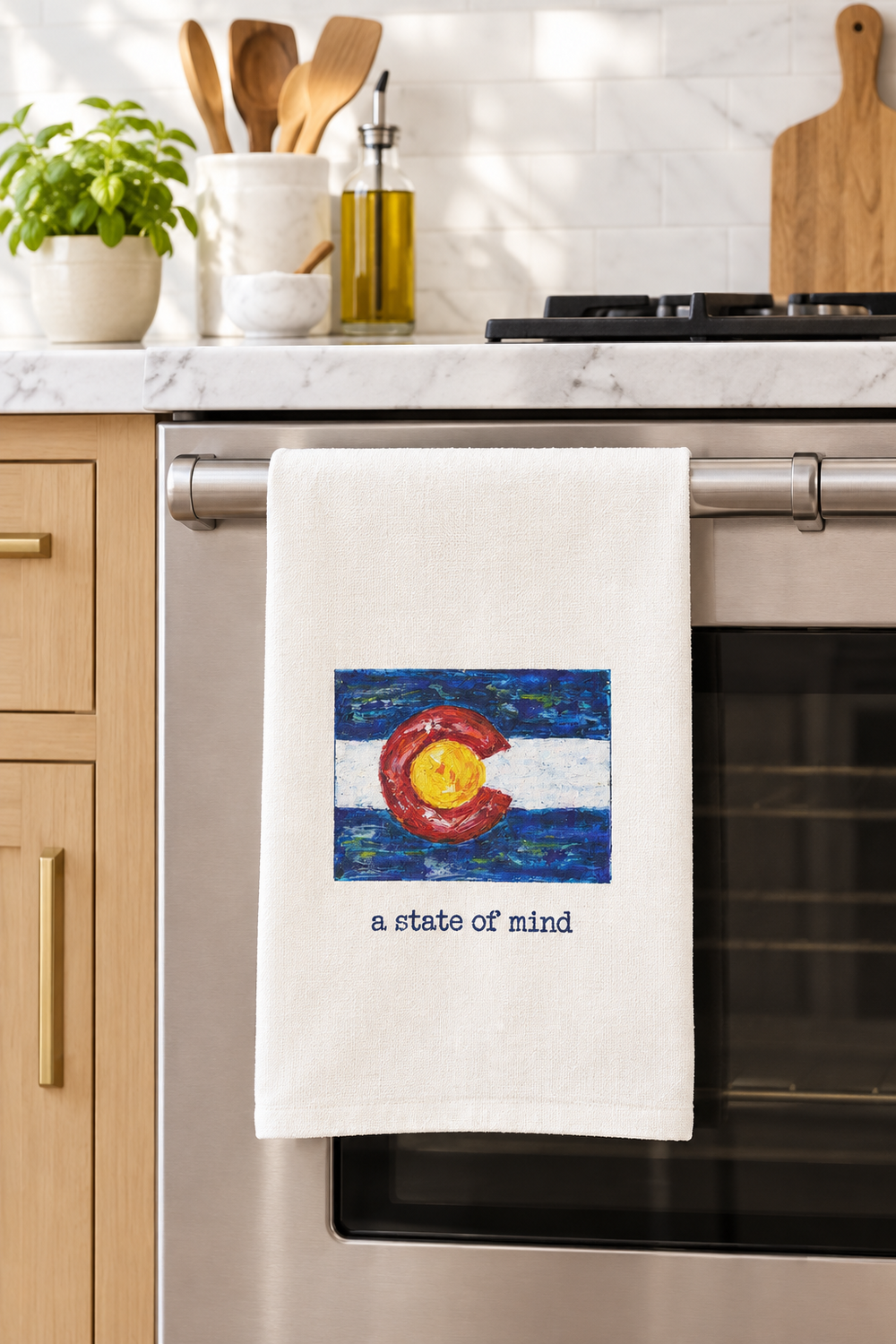White towel with Colorado flag design and 'a state of mind' text on a white background