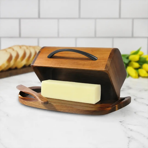 Butterie acacia wood butter dish with an attached flip-top lid, a matte black handle and a matching spreader resting on its cradle.