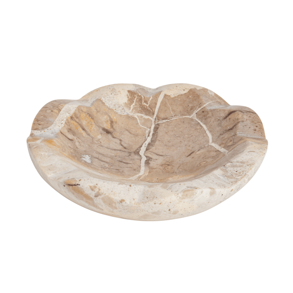 Three marbleized stone bowls in white, gray, and beige on a textured surface with white flowers.