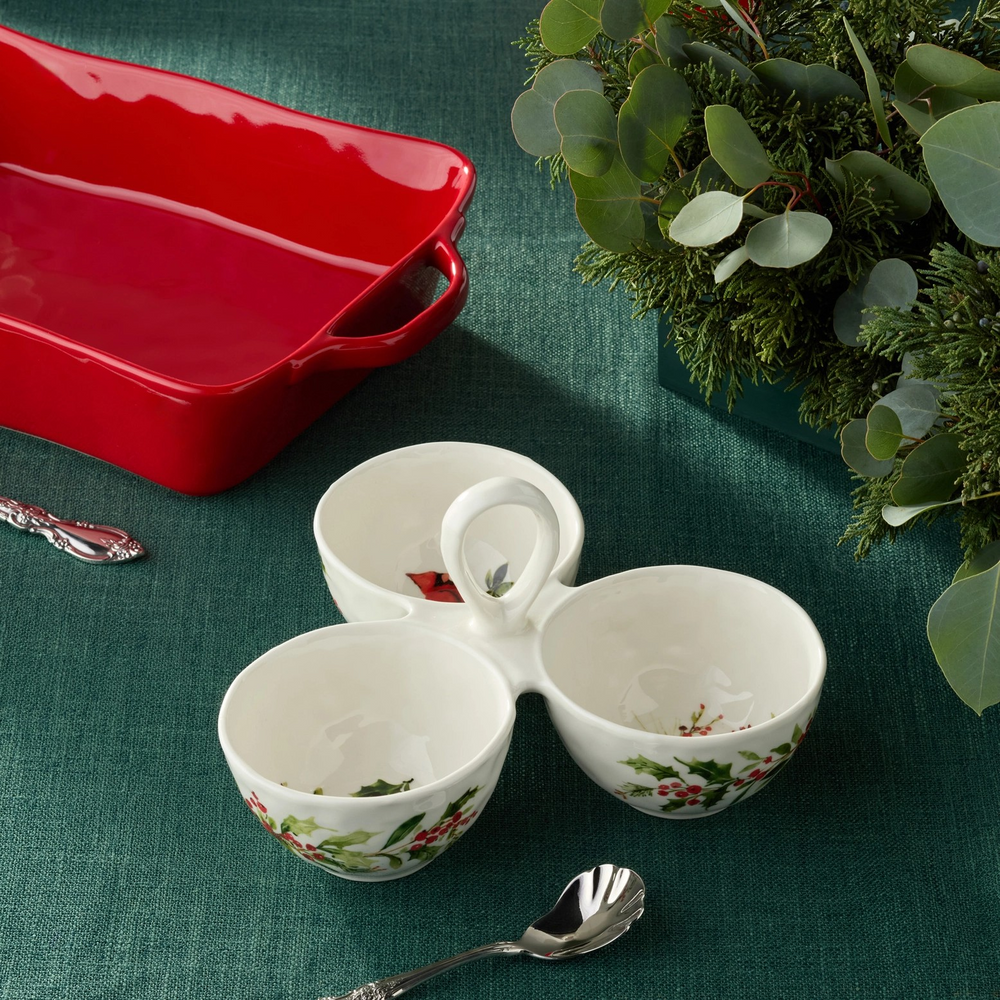 Ceramic three-section condiment server with a center handle, hand painted with holly branches, red berries & a cardinal.