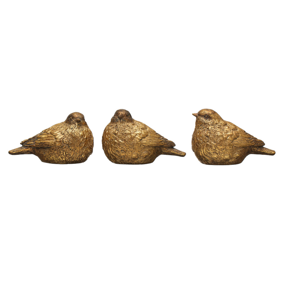 Three metallic gold bird figurines with textured feathers, styled on vintage books and a small decorative box against a light gray background.